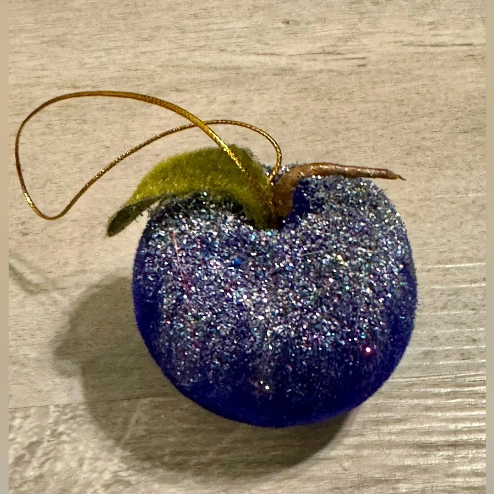 Christmas tree ornament. A plum-shaped ornament covered in glitter. The ornament